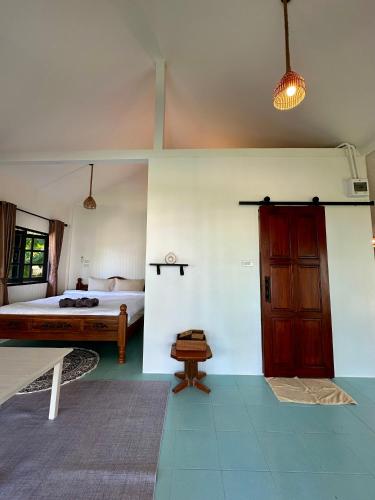 a room with a bedroom with a bed and a door at Chaloklumbay resort2 in Mae Haad
