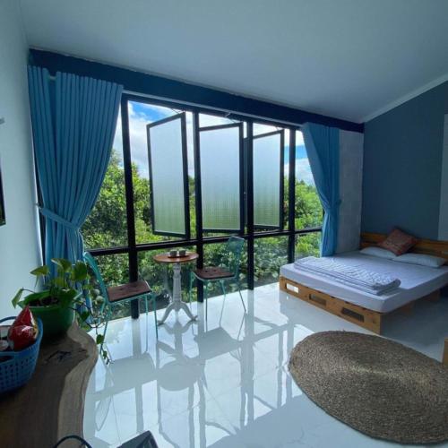 a bedroom with a bed and a large window at Jrai Homestay in Pleiku