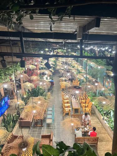 a greenhouse with tables and chairs and plants at Jrai Homestay in Pleiku