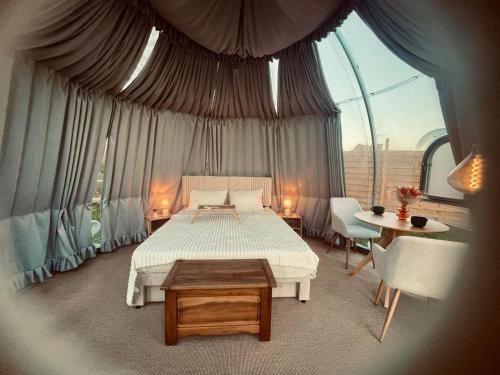 a bedroom with a bed and a large window at Maison Thalène - La Bulle in Aurseulles