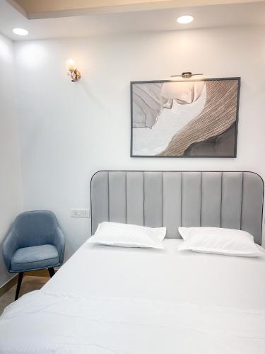 a bedroom with a bed and a blue chair at The Boutique Stay in Noida