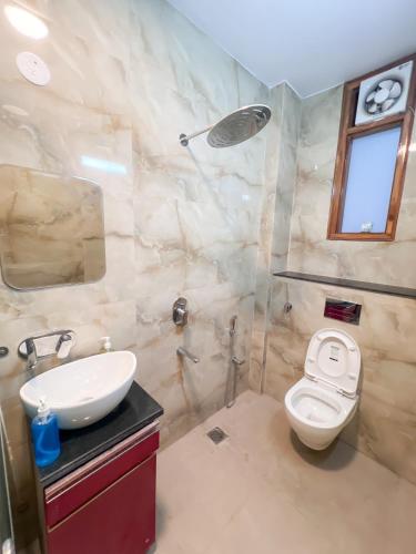 a bathroom with a white toilet and a sink at The Boutique Stay in Noida
