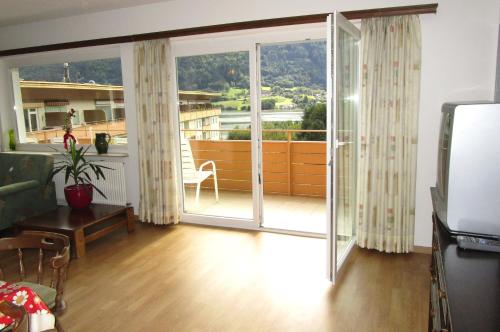 a living room with a large sliding glass door at KASPAR Haus KMB Seeblick Appartement am Ossiacher See mit direktem Seezugang und Hallenbad in Bodensdorf