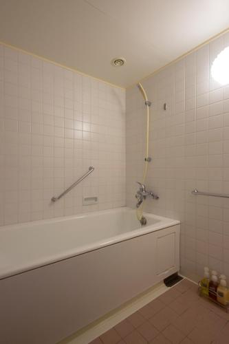 a bathroom with a bath tub and a shower at Hotel Shima Spain Mura in Shima