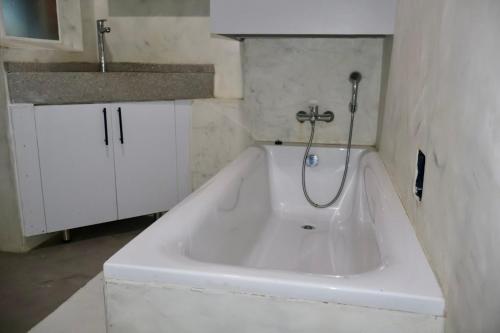 eine weiße Badewanne im Bad mit Waschbecken in der Unterkunft San Remo on Windermere Rd. Humewood Beachfront in Gqeberha