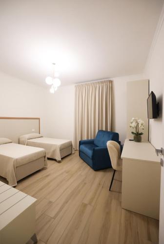 a hotel room with two beds and a blue chair at Villa Nicadè in Corbara