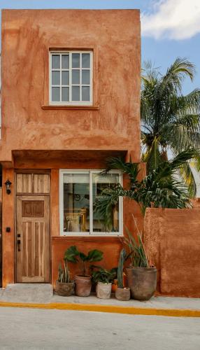 a orange house with plants in front of it at Casa Rocka Boutique Breakfast & Beach Club included in Isla Mujeres