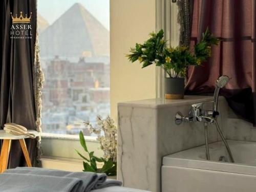a bathroom with a window with a view of the pyramids at NEW ASSER HOTEL PYRAMID in Cairo