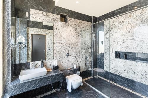 a bathroom with a sink and a shower and a toilet at Raj Leela Heritage Resort By Estherea in Jāmb