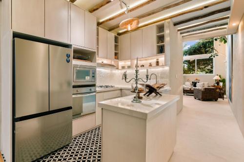 a kitchen with white cabinets and a counter with a refrigerator at Casa Rocka Boutique Breakfast & Beach Club included in Isla Mujeres