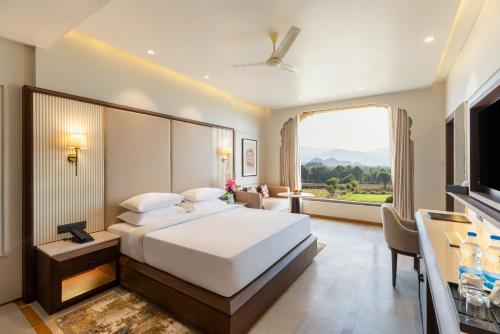a hotel room with a bed and a large window at Raj Leela Heritage Resort By Estherea in Jāmb