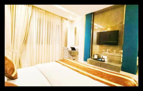 een hotelkamer met een bed en een flatscreen-tv bij The CJ Inter National in Amritsar