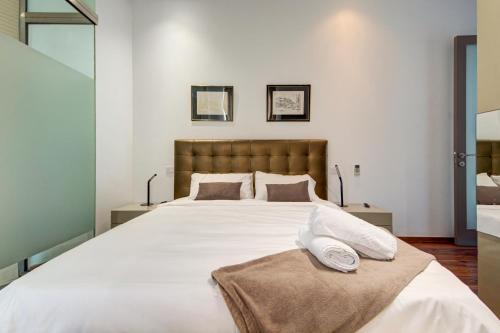 a bedroom with a large bed with white sheets and pillows at St Julian's 2Br Apartment with Private Jacuzzi in St. Julianʼs