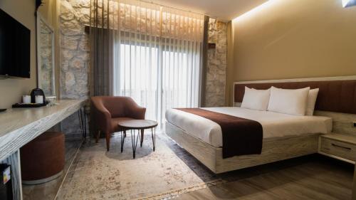 una stanza d'albergo con un letto, una sedia e una finestra di Magical House Hotel a Çatalca