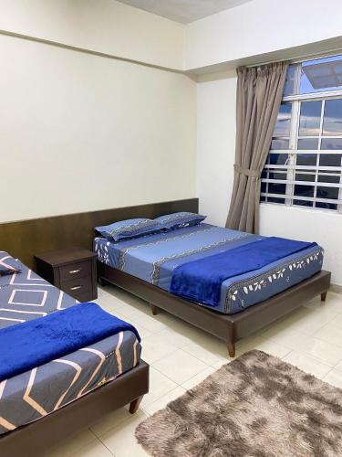 een slaapkamer met twee bedden en een raam bij SMC Homestay Cameron Highlands in Cameron Highlands