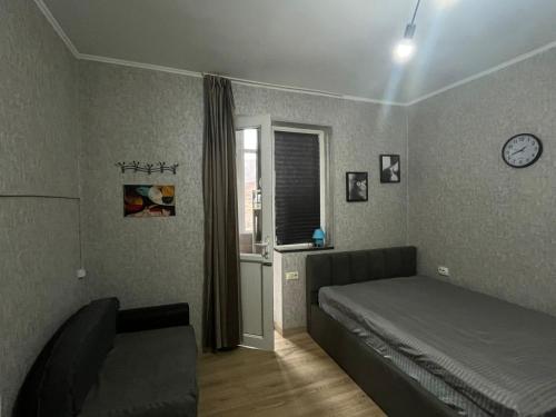 a bedroom with a bed and a couch and a window at Family Studio in Gudauri