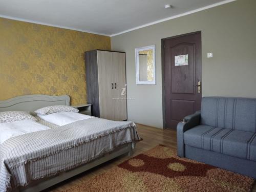 una camera da letto con un letto e una sedia blu di Casa Crăciun a Mănăstirea Humorului