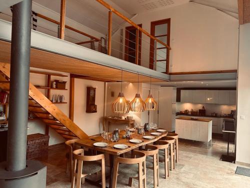 een eetkamer met een lange tafel en een trap bij Gîte de Marcenac in Lalbenque