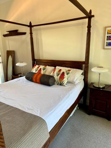 a bed with a wooden frame and pillows on it at York Wildflower Junior Suite in York