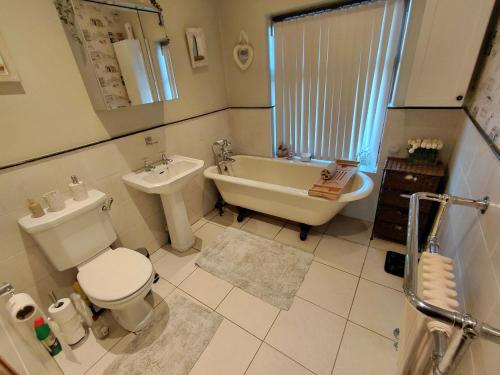 ein Badezimmer mit Badewanne, Toilette und Waschbecken in der Unterkunft Penwortham traditional home in Penwortham