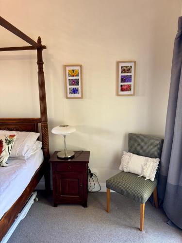a bedroom with a bed and a chair and a lamp at York Wildflower Junior Suite in York