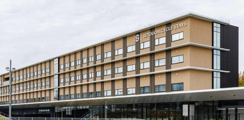 a building with a sign on the side of it at Setouchi Cycle Stays Hiroshima Ujina in Hiroshima