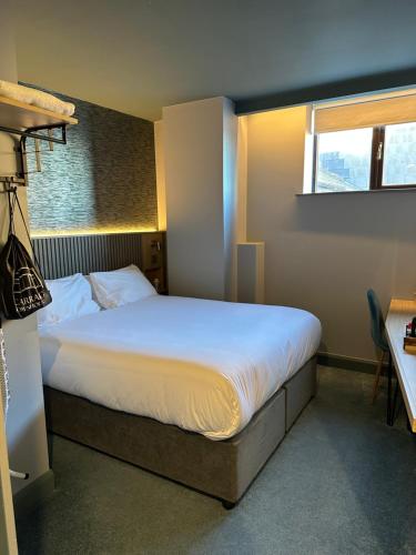 a bedroom with a large white bed with a window at Carraig Townhouse in Blackrock
