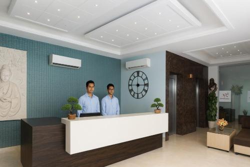 twee mannen bij de receptie in de lobby bij The Ruby Resort Vrindavan # Prime Location # Luxury Rooms # Near Prem Mandir # Restaurant # Big Lawn # Big Parking # By Nandan Group # in Vrindāvan
