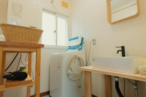 a kitchen with a sink and a white refrigerator at ペコレラ学舎 Teacher House in Yakumo