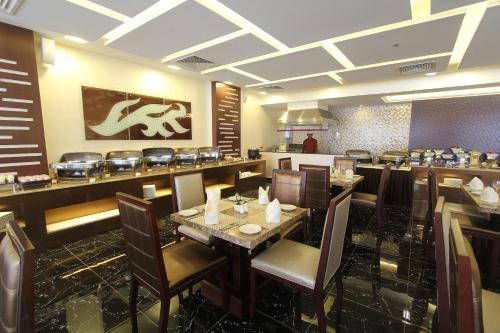 a restaurant with a dining room with tables and chairs at Ivory Grand Hotel Apartments in Dubai