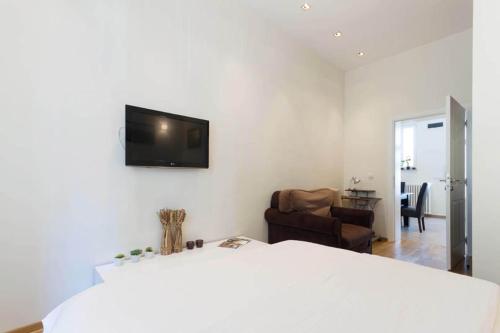 a bedroom with a white bed and a television on the wall at City Break Apartments Chic and Luxury in Belgrade