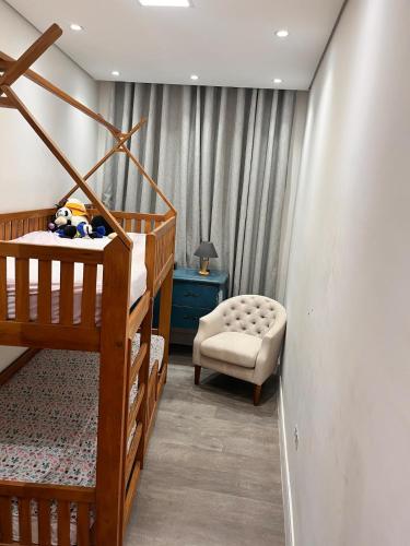 a bedroom with a bunk bed and a chair at Chácara Coração no Mato in Santa Isabel