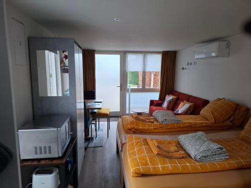 a room with two beds and a living room at Studio Dajan in Almere