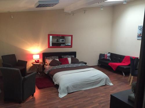 een slaapkamer met een bed en banken in een kamer bij Solo apart in Rīga