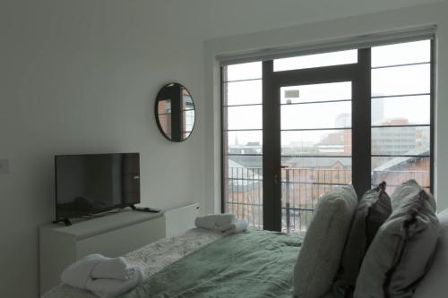 a living room with a tv and a bed and a window at Bright & Contemporary 1BED Apartment in Birmingham in Birmingham