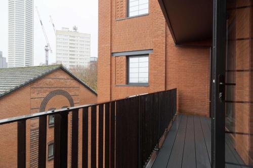 a balcony of a brick building with a wooden deck at Bright & Contemporary 1BED Apartment in Birmingham in Birmingham