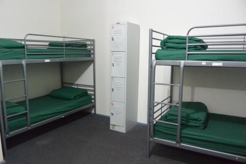 two bunk beds in a room with green sheets at Elizabeth Hostel in Melbourne