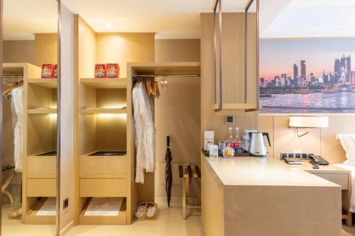 une petite cuisine avec un comptoir et une fenêtre dans l'établissement Sky World Hotel Qingdao, à Qingdao