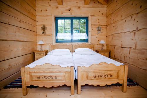 a bedroom with a bed in a log cabin at Chata Warmińska in Łajs