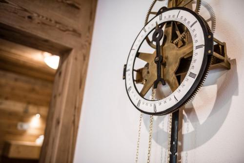 a clock is hanging on a wall at Aurina Lodges in Lutago