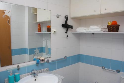 a bathroom with a sink and a mirror at Apartamento Mar e Sol in Ponta Delgada