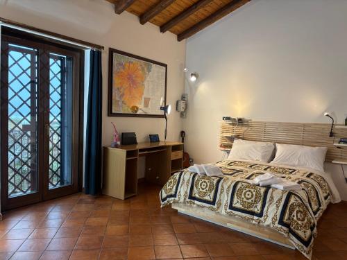 a bedroom with a bed and a desk and a window at Soffio dell'Etna in Puntalazzo