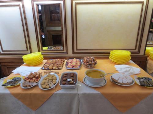 a table with a bunch of different types of food at Hotel Italia City Center in Mantova