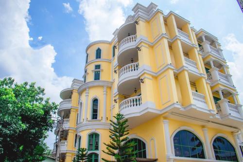 a yellow building with white balconies on it at Siri Grand Bangkok Hotel in Bangkok