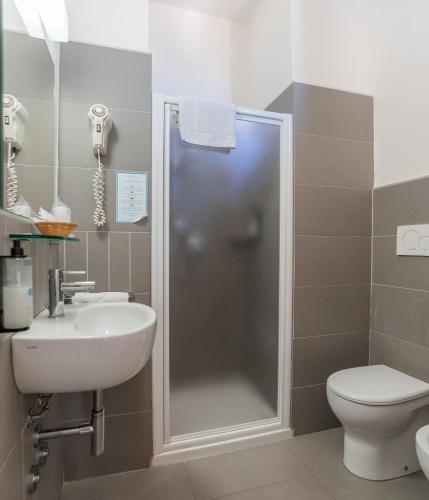 a bathroom with a shower and a sink and a toilet at Hotel Atlas in Gabicce Mare