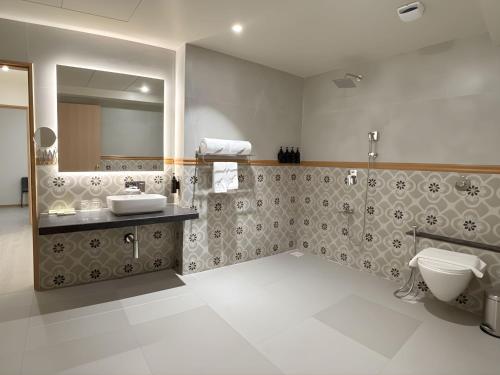 een badkamer met een toilet, een wastafel en een spiegel bij Samrat Studios in Pune