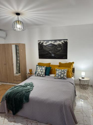 ein Schlafzimmer mit einem großen Bett mit gelben Kissen in der Unterkunft Aqua longe Saint-François in Saint-François
