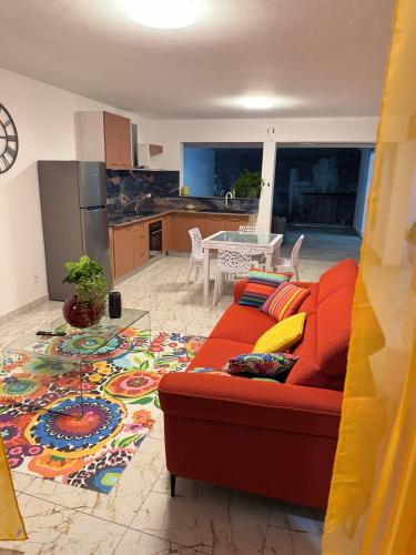 a living room with a red couch and a kitchen at Aqua longe Saint-François in Saint-François