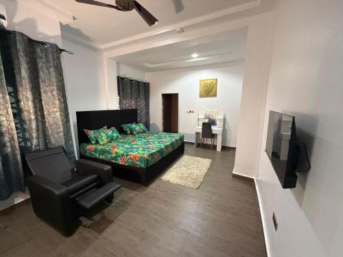 AvenawMiky Hillside Lodge的一间卧室，配有一张床、一把椅子和一台电视机