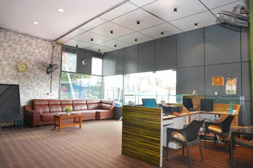an office with a couch and a desk with a computer at Hotel Kakatiya Pride in Warangal